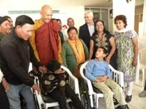 Venerable Bhikhu Sanghsena giving wheelchair to beneficiaries